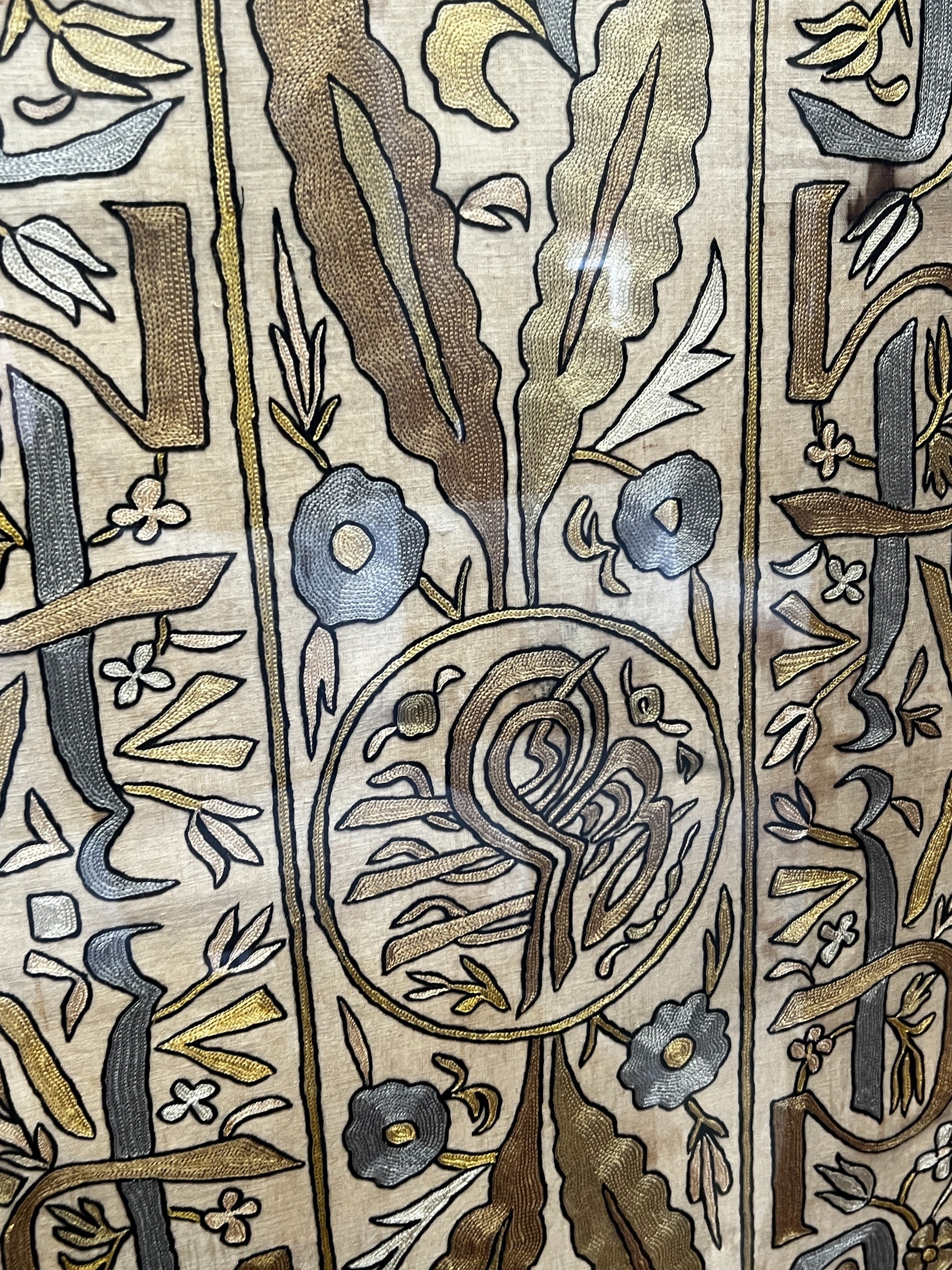 A polychrome embroidered panel, framed, the panel width 51cm, height 192cm